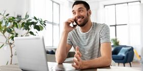 man on phone in front of computer