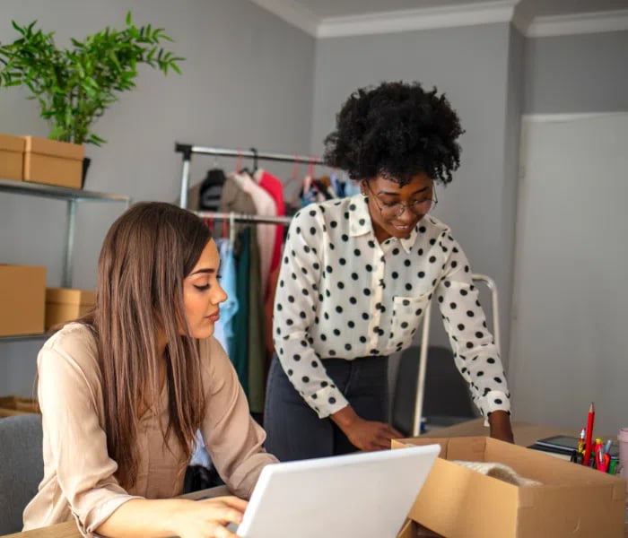 Two small business owners preparing a package for delivery