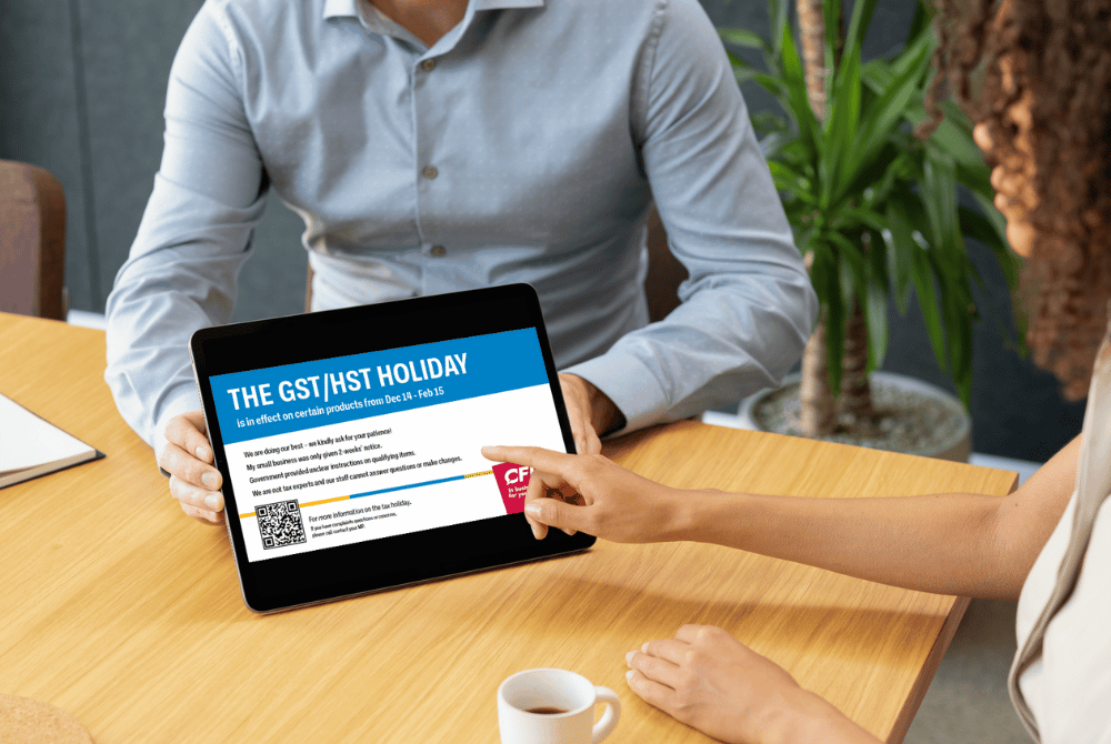 Small business owner checking a CFIB poster related to GST holiday on her tablet