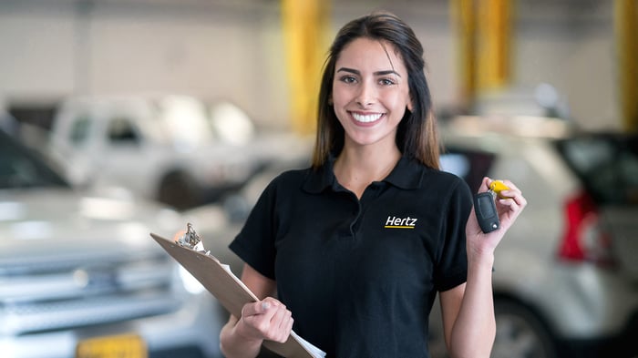 Employé de Hertz tenant des clés et un presse-papiers
