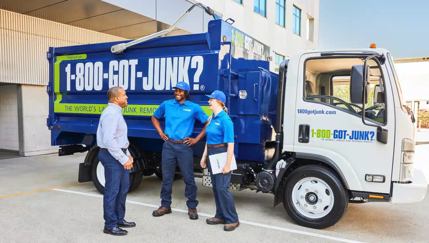 Two employees from 1-800-GOT-JUNK? talking with a small business owner in Canada