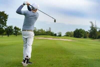 Joueur de golf en train de balancer son club de golf pour frapper la balle