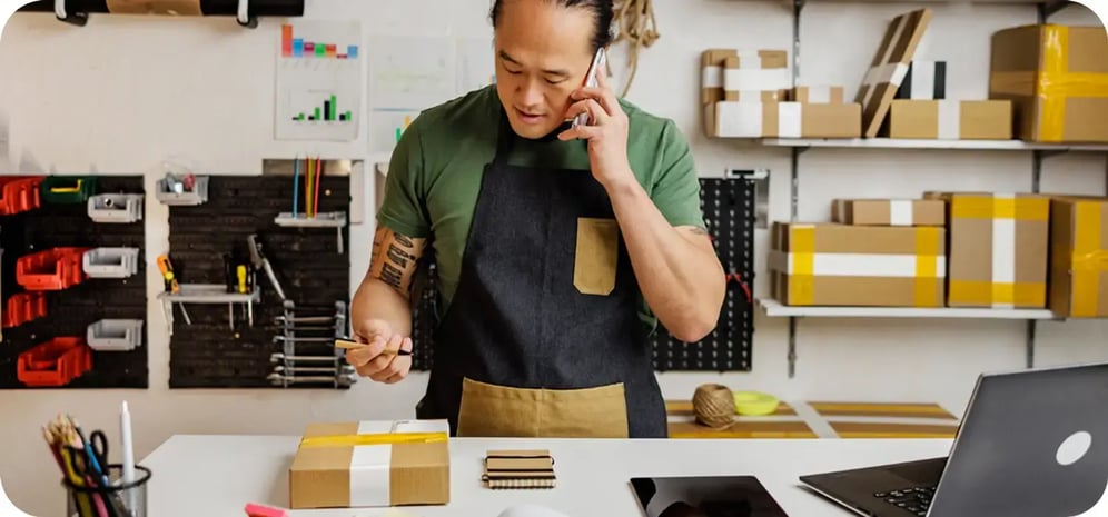 Business owner on the phone while setting up a package