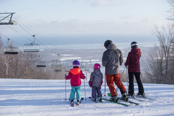 Family of four skiing on top of Blue Mountain hill