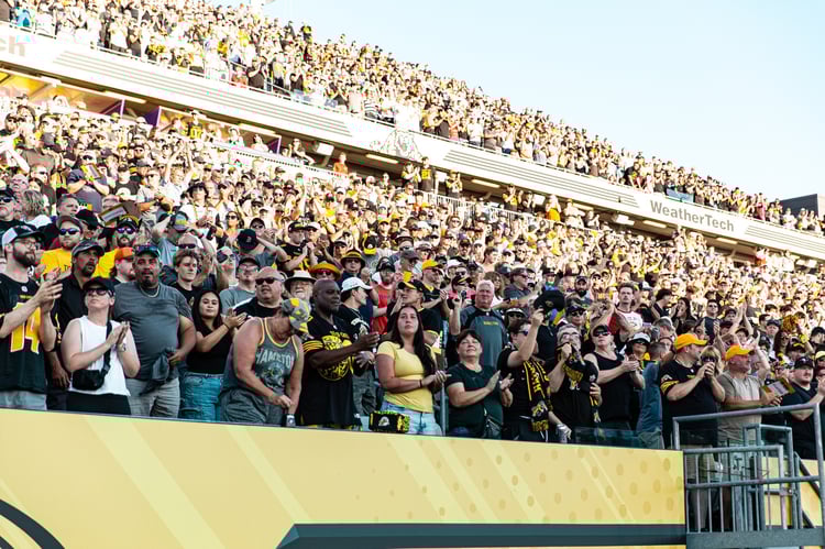 Hamilton Tiger-Cats fans cheering in the stands.