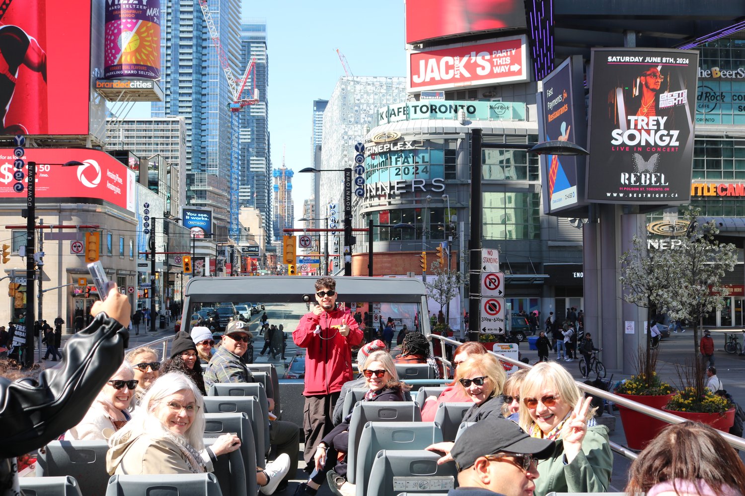 Guests and tour guide on upper level of open top bus