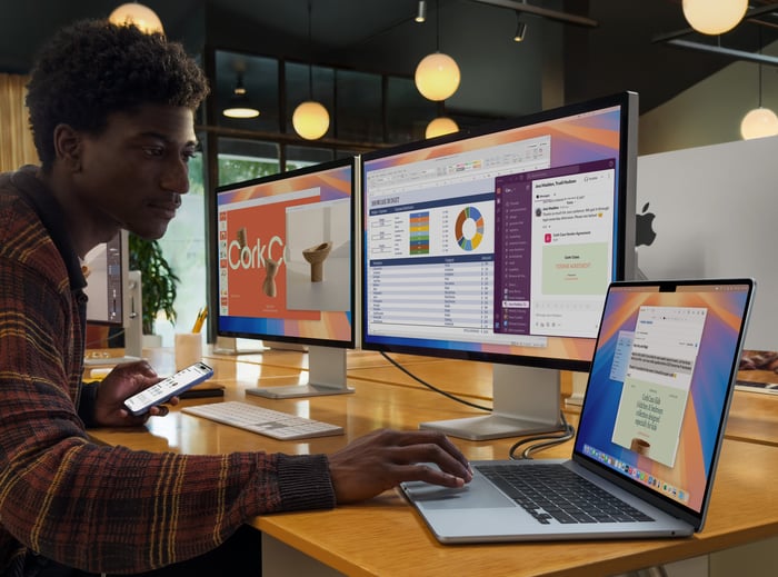 Propriétaire d'une petite entreprise travaillant sur son Macbook.