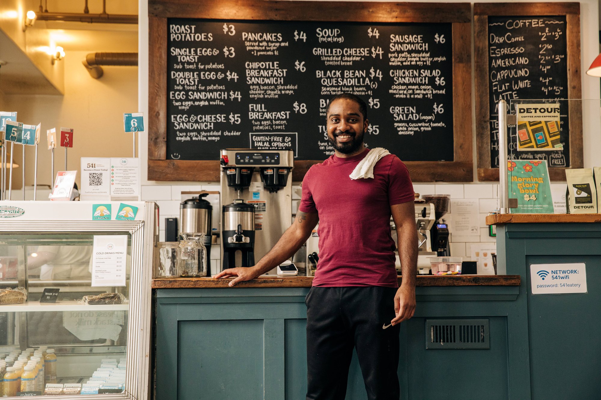 Le propriétaire du café sourit devant les machines à café
