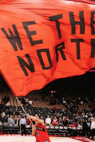 Un joueur des Raptors de Toronto agite un drapeau «&nbsp;We The North&nbsp;» sur le terrain.