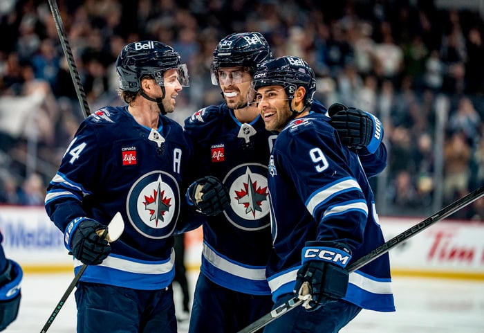 Winnipeg Jets players rallying together on the ice.