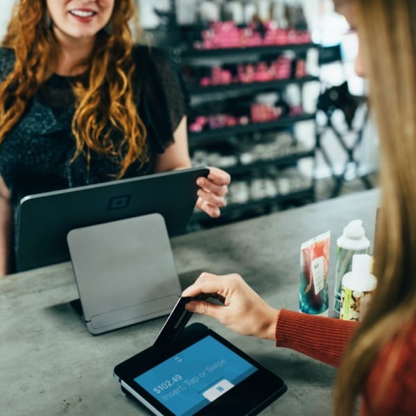 A small business owner on the verge of accepting payment from a customer in her store