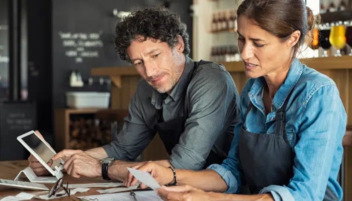 Two small business owners checking their costs