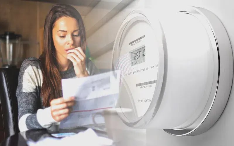 Image of a worried small business owner reading her electricity bill beside an electricity counter