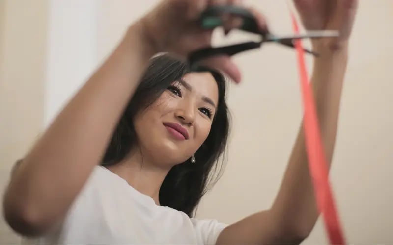 Small business owner cutting a red tape with scissors
