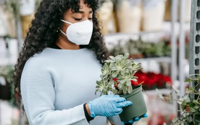 Small business owner wearing a mask in her shop