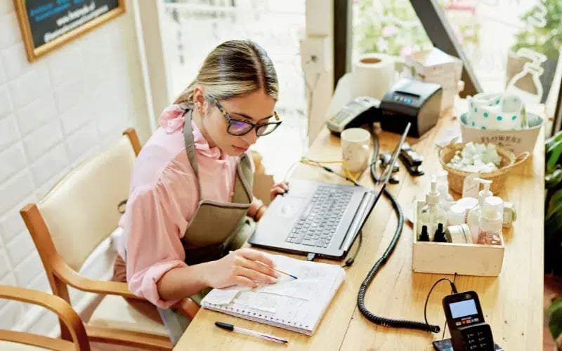 Small business owner calculating her taxes in her store