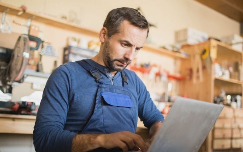 Small business owner working on a laptop in a workshop