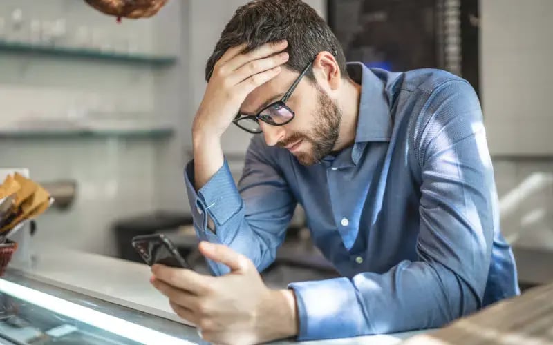 Small business owner looking at his cellphone