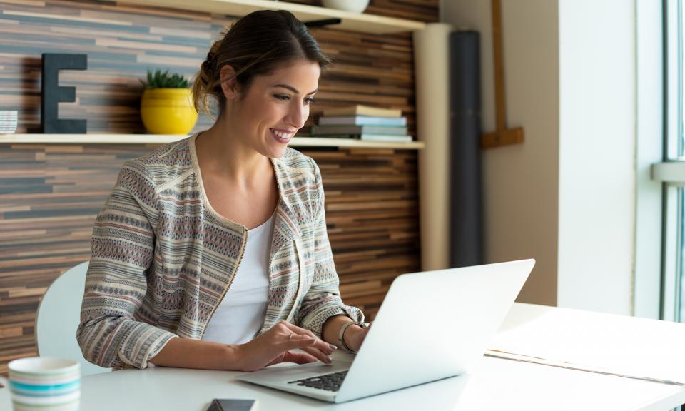 Woman smiling while working on her laptop