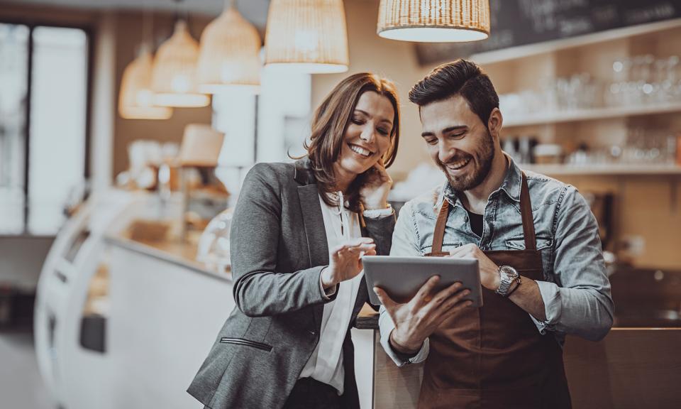 happy woman and man reviewing an order on a tablet