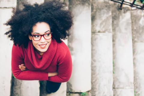 Aerial view of smiling confident woman looking up with her arms crossed