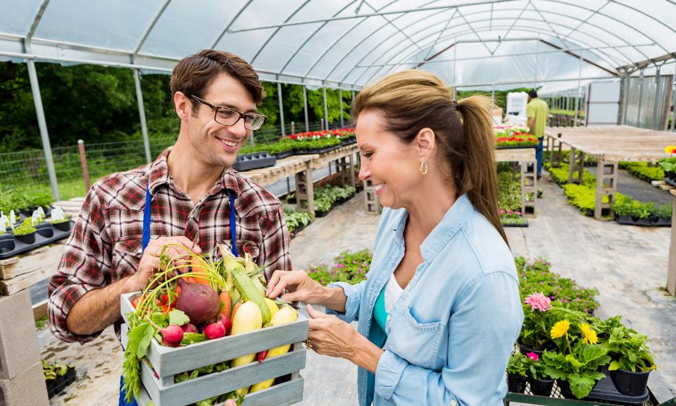 Client et agriculteur regardant une boîte de produits