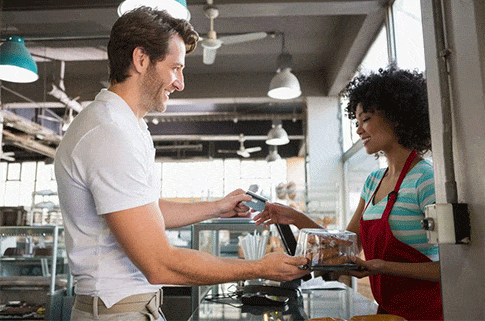 Smiling-customer-paying-by-credit-card-at-the-bakery-min