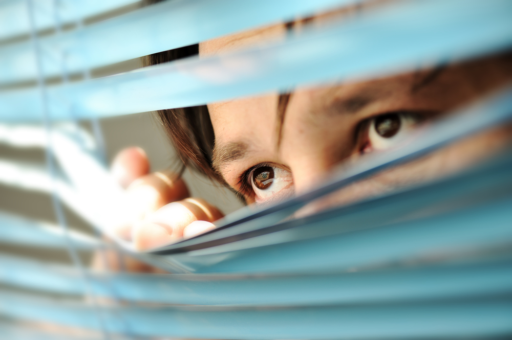 Person inside their home looking out 