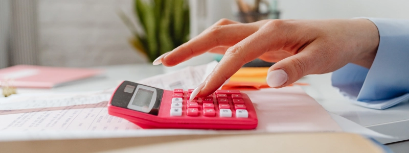 A small business owner is using her calculator to see how she could repay her CEBA loan