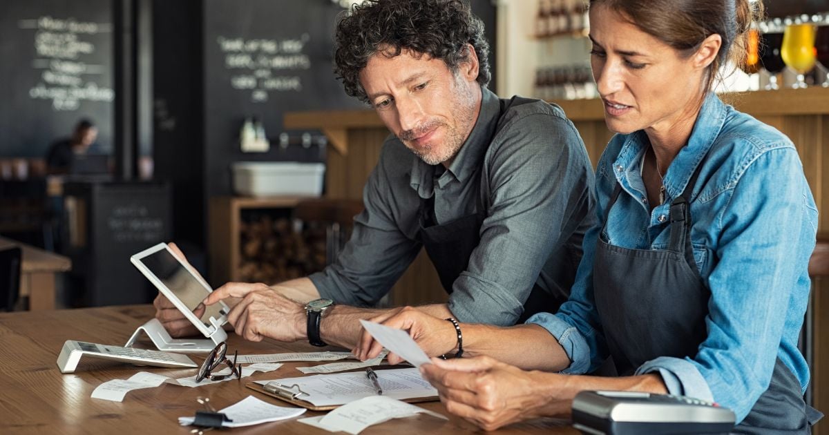 Two small business owners reading their tax documents