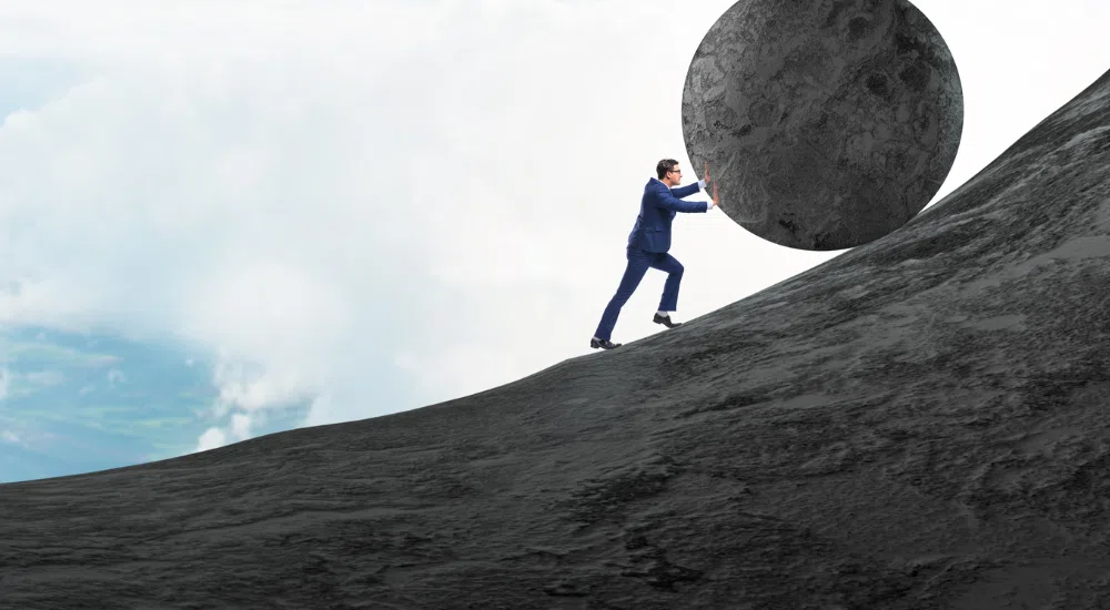 Small business owner pushing a stone symbolizing the weight of payroll tax on small business owners in general