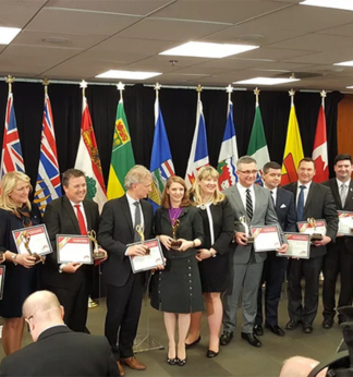 Un dirigeant de la FCEI présente le Prix Ciseaux d’or aux ministres du Commerce du Canada pour souligner la signature de l’Accord de libre-échange canadien (ALEC) en 2017.