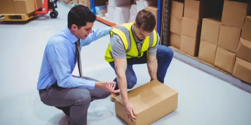 Manager helping employee carry box
