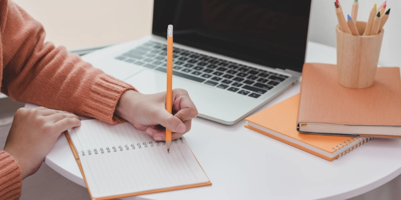 Person writing on notebook
