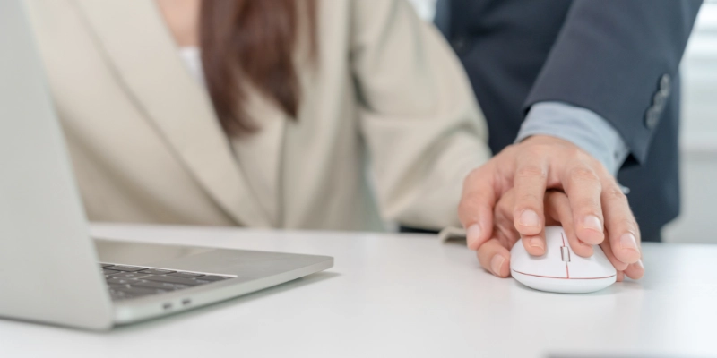 Man with his hand on woman's over computer mouse