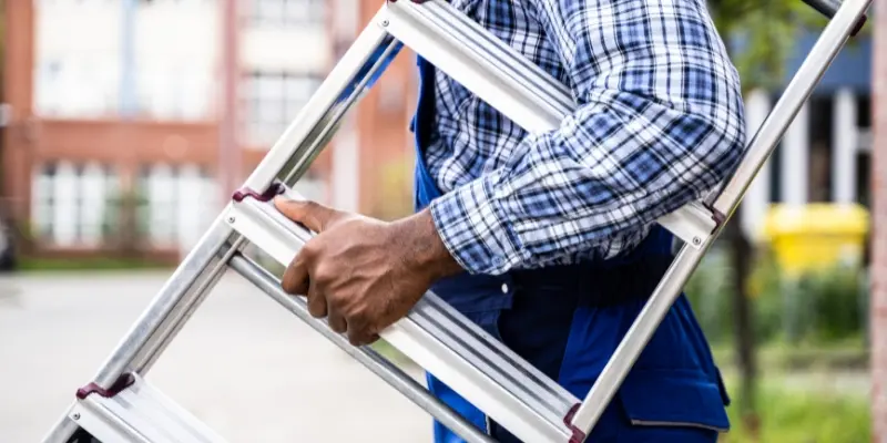 Handyman carrying ladder