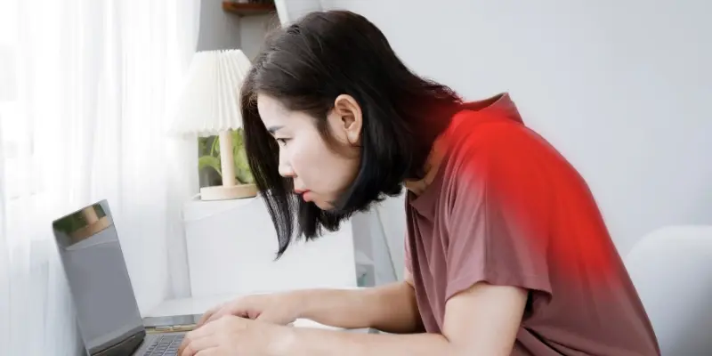 Un employé se penche pour lire un ordinateur portable