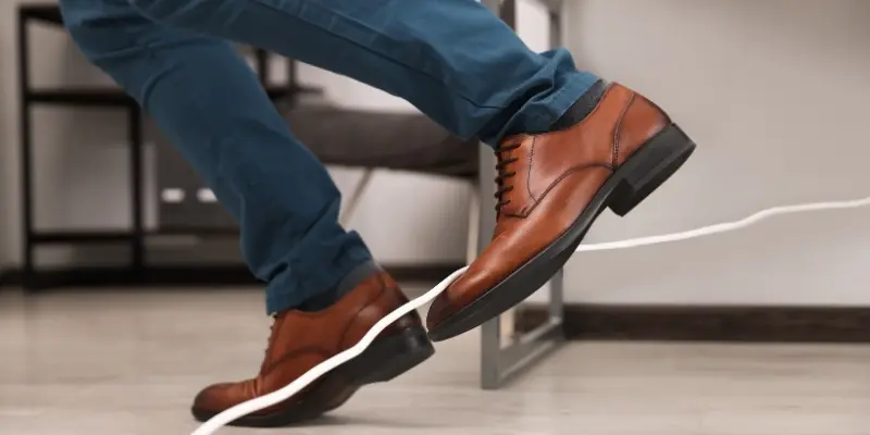 Une personne trébuche sur un câble dans un bureau