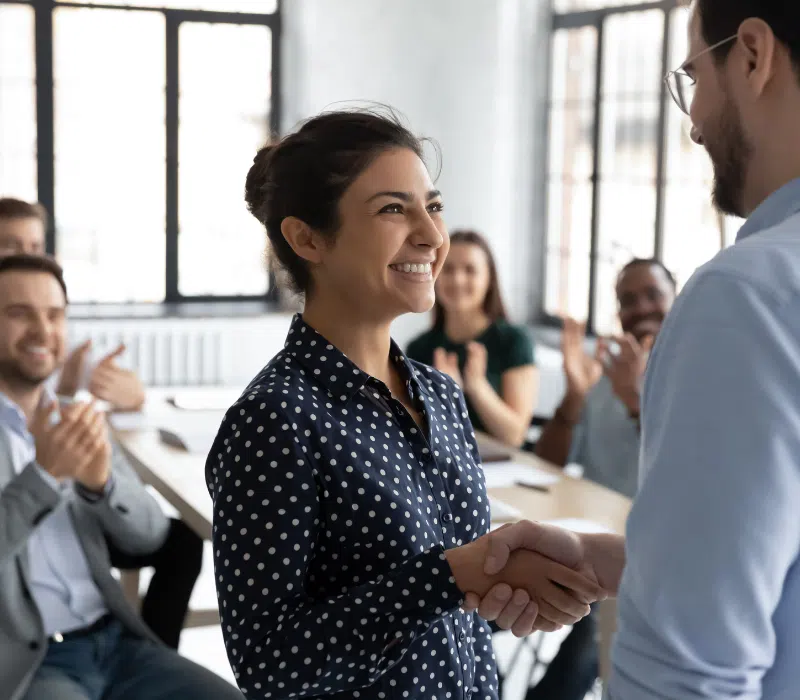 An employee of a small business being congratulated for her work to help with employee retention