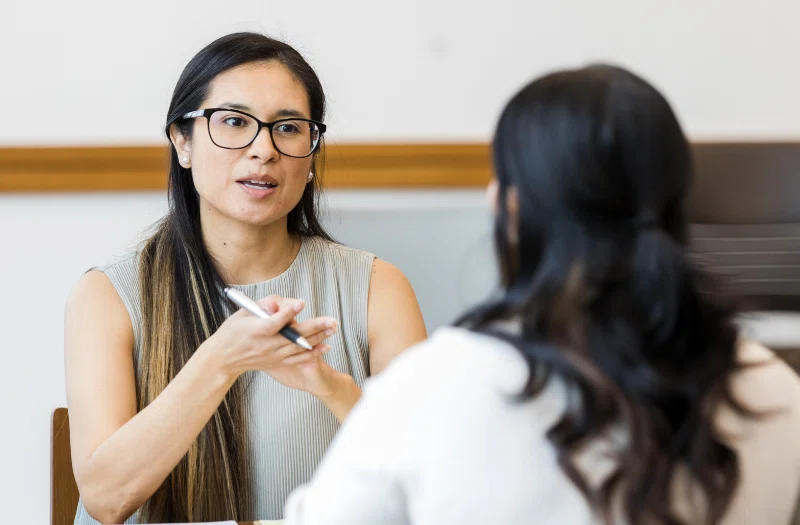 Manager of a small business company conducting performance review for one of her employees