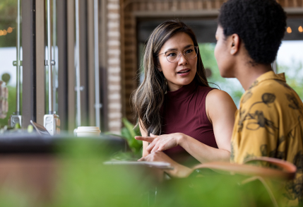 A manager having a disciplinary conversation with an employee in coffee shop. 