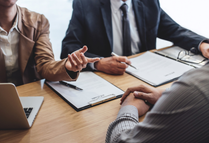 Two professionals conducting a job interview with a candidate in an office setting.