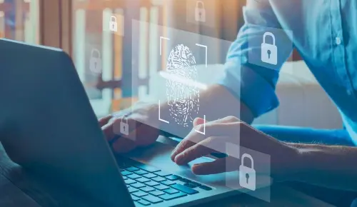 Businessman working on his laptop with images of locks superimposed on the image, symbolizing fraud