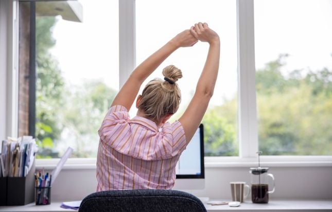 Femme qui s'étend à son bureau