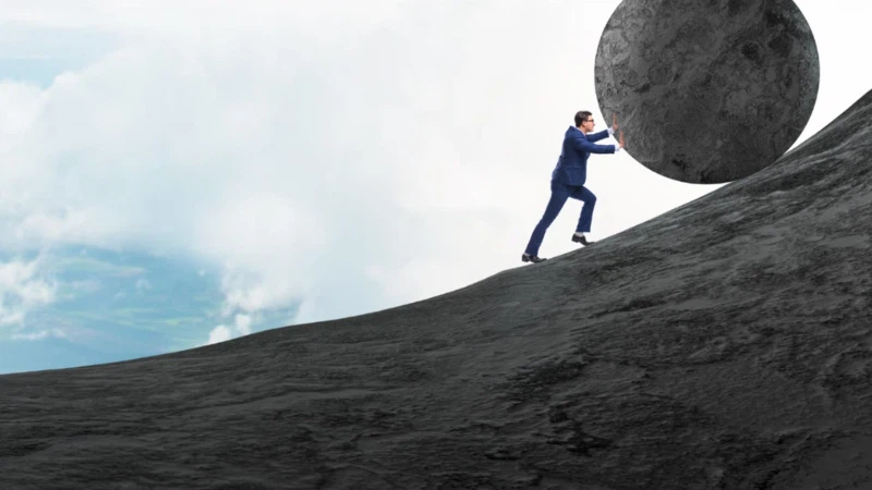 Small business owner pushing a stone symbolizing the weight of payroll tax