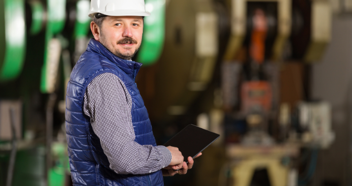 Owner of manufacturing business reviewing information on tablet representing carbon tax rebate