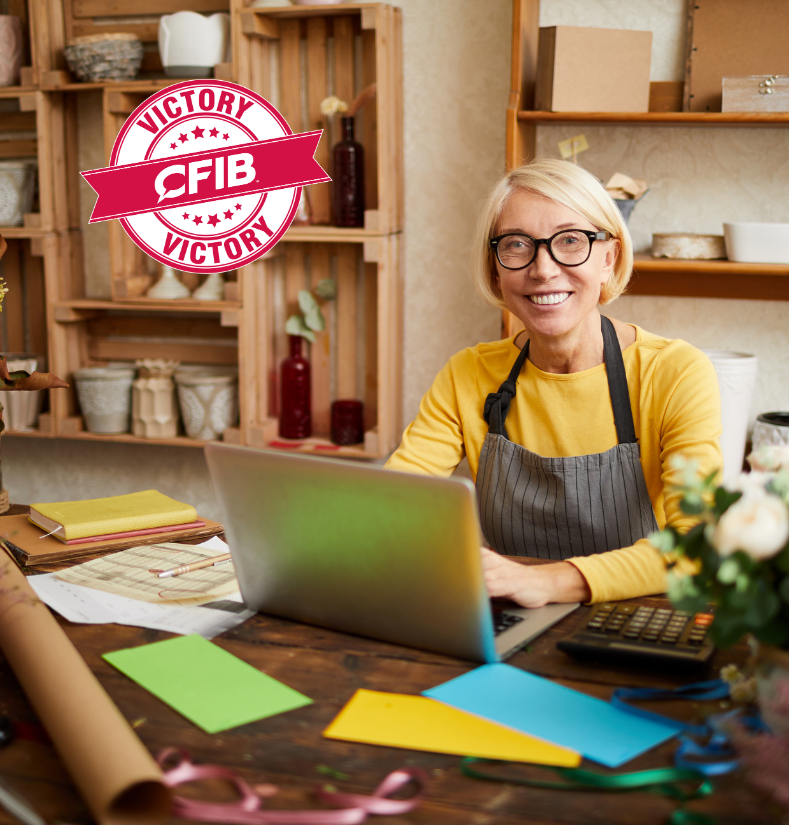 small happy business owner working at a desk