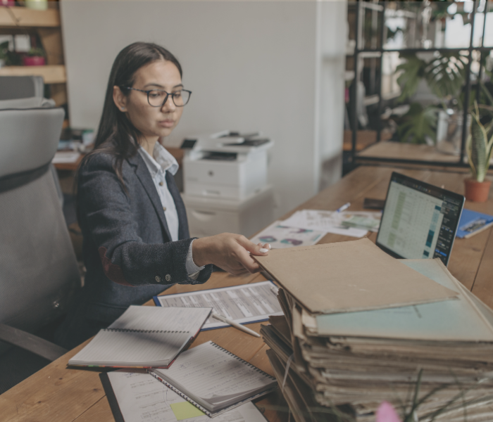 women at a desk with a computer and paperwork representing federal budget management