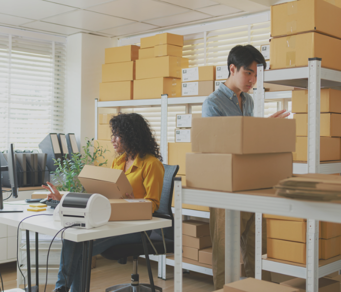 employees in a storage room on a computer representing doing payroll taxes