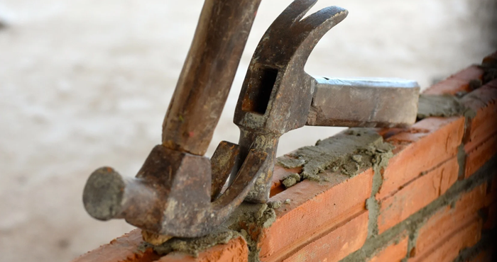 two hammers on a brick wall